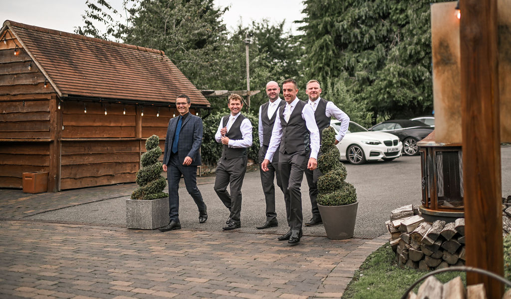 Groom and his best men walking toward the Stables barn at Nuthurst Grange
